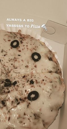 a pizza with black olives on it sitting in a white cardboard box that says, always a big passess to pizza