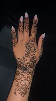 a woman's hand with henna tattoos on it