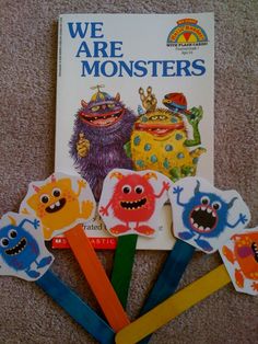 the children's book we are monsters is laying on the floor next to five colorful toothbrushes