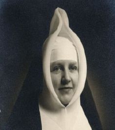 an old black and white photo of a woman wearing a nun's outfit with a hood over her head