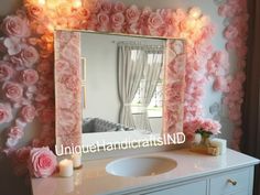 a bathroom vanity with flowers on the wall and a mirror above it that is decorated with pink roses