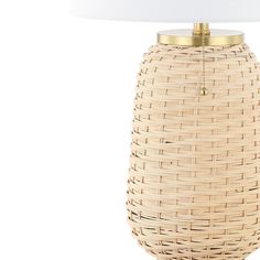 a wicker lamp with a white shade on it