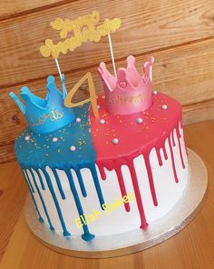 two birthday cakes decorated with colorful icing and decorations on top of each other, sitting on a wooden table