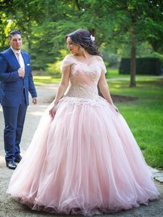 a woman in a pink dress standing next to a man