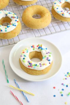 there are many donuts with white frosting and sprinkles on the plate