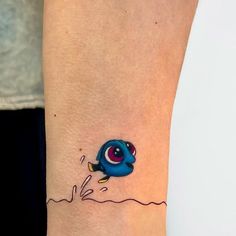 a small tattoo on the ankle of a woman's leg with an evil looking fish coming out of water