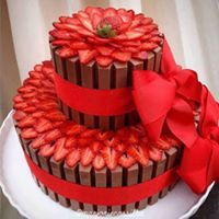 a three tiered chocolate cake with strawberries on top