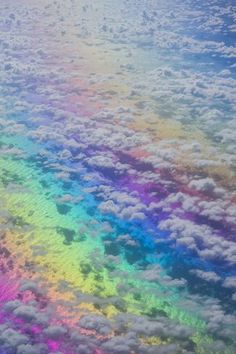 an aerial view of clouds and rainbow colors