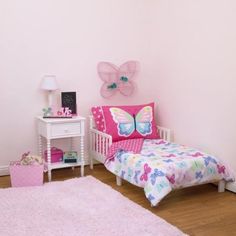 a small child's bedroom with pink walls and white furniture