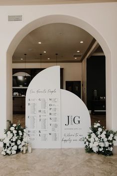 a large white sign sitting in the middle of a room next to flowers and candles