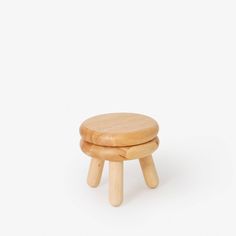 a small wooden stool sitting on top of a white surface