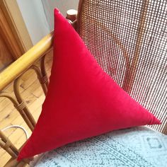 a red pillow sitting on top of a wooden chair