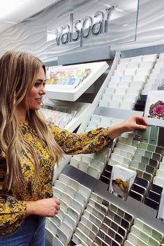 a woman is looking at some tiles in a store