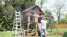 a man standing in front of a wooden structure with ladders on the side and trees behind him