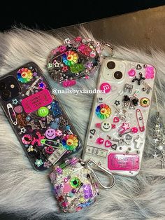 three cell phones sitting on top of a fur covered floor next to each other with charms