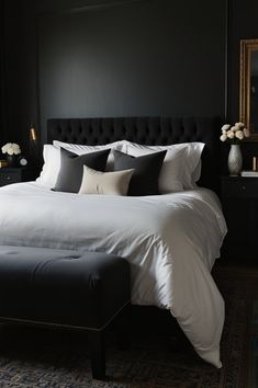 a bedroom with black walls and white bedding