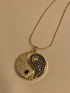 Our Gold Filled Yin Yang pendant is a unique and fashion-forward way to show your vibe. Each day this necklace reminds you of finding and maintaining balance. Secured on a Gold Filled Snake Chain, this pendant is adorned in Black and White Cubic Zirconias to reflect the sun's rays while the other is a polished black stone to show the night sky. This metaphysical symbol of balance and harmony will only bring these moments. 14kt Gold Filled Hypoallergenic Hand made with love Water Resistant Black Gold Snake Chain, Gold Snake, Black Stone, Gold Filled Chain, Each Day, Snake Chain, 14kt Gold, Yin Yang, Cuba