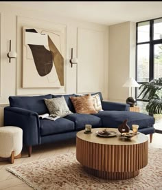 a living room with a blue couch and coffee table in front of a large window