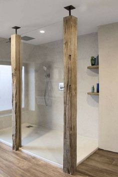 a bathroom with wooden floors and walls, including a walk in shower next to the tub