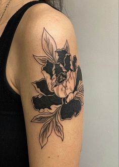 a black and white flower tattoo on the left arm, with leaves around it's edges