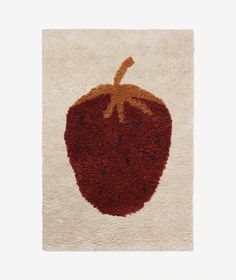 a red and white rug with a strawberry on the top, in front of a white background