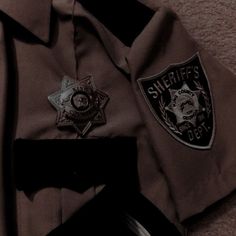 a sheriff's badge is shown on top of a brown jacket and black pants