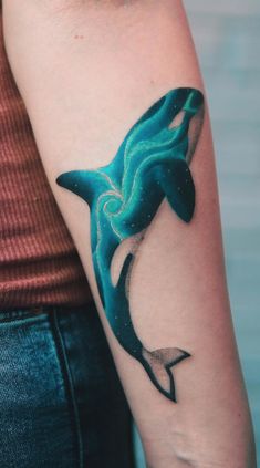 a woman's arm with a tattoo of an orca whale on the side