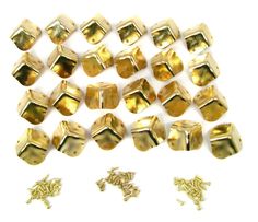 gold plated metal beads and screws on a white background, with two smaller ones in the foreground