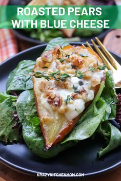 roasted pears with blue cheese and spinach on a black plate next to salad