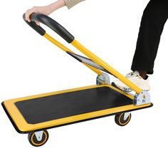 a person on a yellow hand truck with wheels