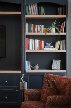 a living room filled with furniture and bookshelves next to a flat screen tv