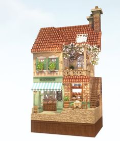 a building with green shutters and flowers on the roof is made out of cardboard