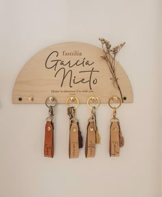 four keychains hanging from a wooden sign with the name gaia miet written on it