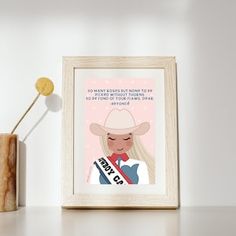 a framed poster with a drawing of a woman wearing a cowboy hat on top of a shelf