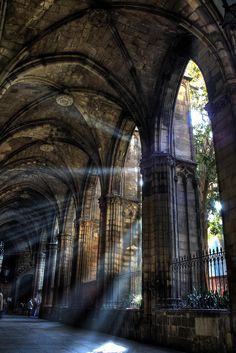 the sun shines through an old cathedral in black and white, as it casts long shadows on the wall