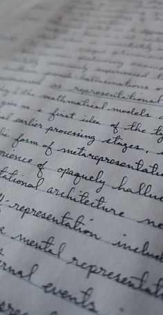 a close up of handwriting on top of a piece of paper with cursive writing