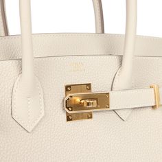 This Birkin is in Craie togo leather with gold hardware and has tonal stitching, front flap, two straps with center toggle closure, clochette with lock and two keys, and double rolled handles.The interior is lined with Craie chevre and has one zip pocket with an Hermes engraved zipper pull and an open pocket on the opposite side.Collection: WOrigin: FranceCondition: New and never worn (Plastic on hardware)Accompanied by: Hermes box, Hermes dustbag, clochette, lock, two keys, clochette dustbag, felt, carebook, ribbonMeasurements: 11.75" width x 9.5" height x 6" depth; 4.25" handle drop Classic Togo Leather Bag With Gold-tone Hardware, Luxury Everyday Bag In Togo Leather With Turn-lock Closure, Timeless Togo Leather Bag With Gold-tone Hardware, Luxury White Bags With Turn-lock Closure, Luxury White Bag With Turn-lock Closure, Timeless Togo Leather Bag With Lock, Timeless Bags With Metal Hardware And Togo Leather, Timeless Togo Leather Bag With Metal Hardware, Luxury Everyday Calf Leather Bag With Lock