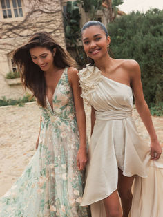 two women standing next to each other in dresses