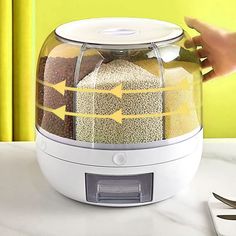 a person is holding the lid on an automatic food dehydrator that has five different types of grains in it