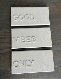 three white ceramic signs that say good vibes only on wood background, with the words'good vibes only'written across them