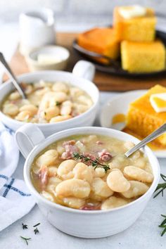 two white bowls filled with soup on top of a table