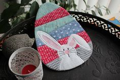 a close up of a pot holder on a tray with a candle and some scissors