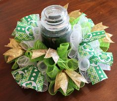 a green and gold christmas wreath with a jar on the top that says st patrick's day