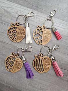 four wooden key chains with tassels on them