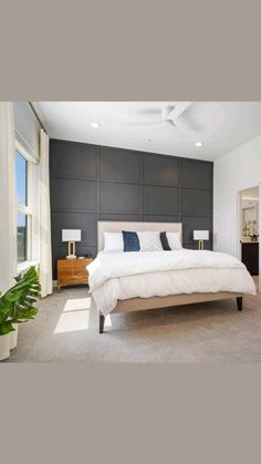 a large white bed sitting in the middle of a bedroom