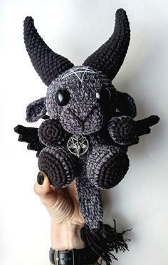 a crocheted black and white stuffed animal with horns