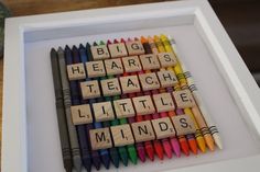 there are many different colored crayons arranged in a shadow box with the words'big hearts teach little minds '