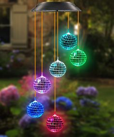 multicolored disco ball wind chime hanging in front of flowers