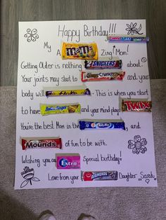 a birthday card with candy bars on it and someone's feet next to it