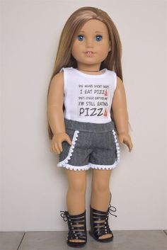 a doll is standing next to a wall wearing a white shirt and gray shorts with the words eat pizza on it